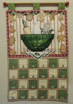 a calendar hanging on the wall in front of a white wall with green and red decorations