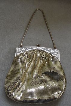 A circa early 1940s Whiting and Davis gold tone mesh evening bag in wonderful unused condition. The gold tone frame has a beautiful engraved scroll and floral design Frame #(2814) with a kiss clasp. The interior is W&D trademark peach watermark satin lining which is in mint with no staining. The bag has a round serpentine chain handle. Measures 6.5"l x 6.5"w at the bottom. The handle is approx 5.5"long. Excellent overall condition. Gold Rectangular Bag For Luncheon, Antique Gold Evening Bag For Formal Events, Antique Gold Evening Bag For Formal Occasions, Antique Gold Bags For Wedding, Victorian Gold Evening Bag For Weddings, Vintage Gold Evening Bag For Wedding, Antique Gold Formal Bags, Victorian Gold Evening Bag For Party, Gold Victorian Evening Bag For Weddings