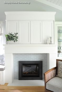 a living room with a fireplace and white cabinets