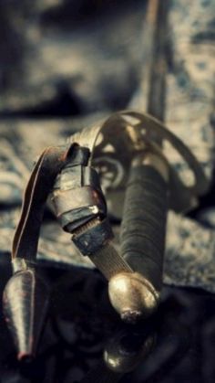 an old metal object sitting on top of a piece of wood next to a knife