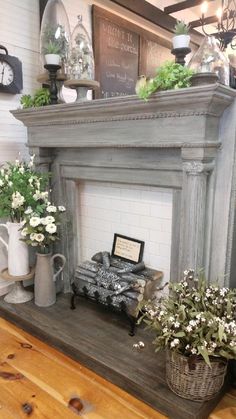 an old fireplace is decorated with white flowers and greenery on the mantels