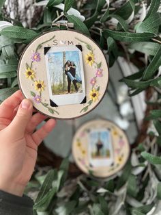 someone is holding up an ornament to show the couple's photo on it