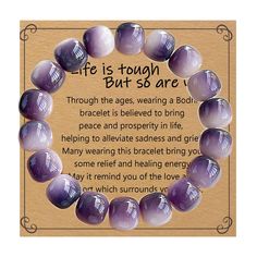 a purple bead bracelet with an inspirational poem written in the center on top of it