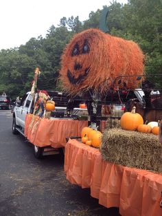 a truck with hay bales and pumpkins on the back