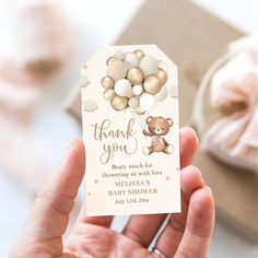 a person holding up a thank you card with a teddy bear and balloons on it