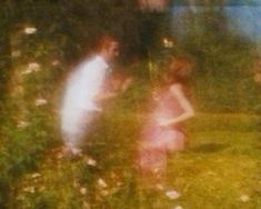 two people standing next to each other in the grass