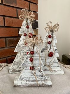 two wooden christmas trees with berries tied to them