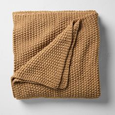 a brown blanket folded on top of a white wall