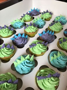 cupcakes with green and purple frosting in a box