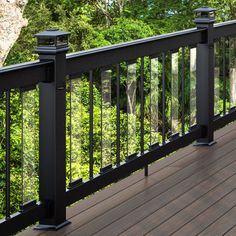 a deck with railings and trees in the background