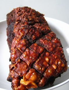 two pieces of meat sitting on top of a white plate