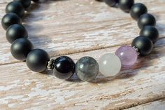 This asexual flag bracelet is the perfect way to subtly show off your ace pride! The bracelet is made with four focal beads arranged in the colors of the asexual pride flag, made from amethyst, white jade, smokey quartz, and black onyx. The bracelet is finished with matte black onyx beads, as well as two silver tone spacer beads. Each gemstone bead is 8mm in size, and strung onto a high quality elastic cord. The bracelet pictured is 7 inches in length. If you need a bracelet in a size that is no Asexual Flag, Flag Beads, Flag Bracelet, Pride Jewelry, Ace Pride, Pride Jewellery, Pride Bracelet, Asexual Pride, White Jewelry Box