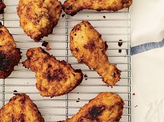 four pieces of fried chicken on a cooling rack