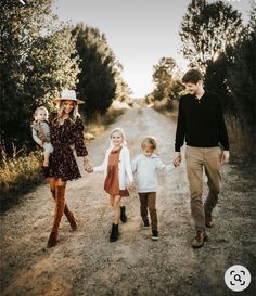 a family walking down a dirt road holding hands