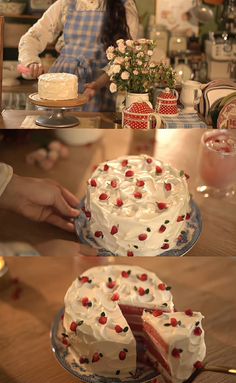 a woman is decorating a cake with white frosting and strawberries on it