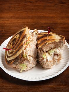 a sandwich cut in half on a paper plate