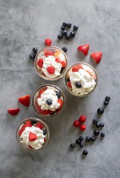 three desserts with strawberries, blueberries and raspberries in small bowls