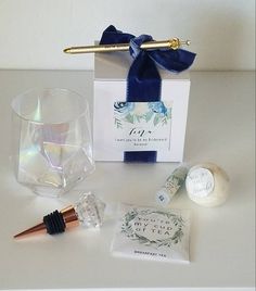 an assortment of items including a wine glass, toothbrush and other items are displayed on a white surface