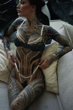 a woman with tattoos sitting on a couch