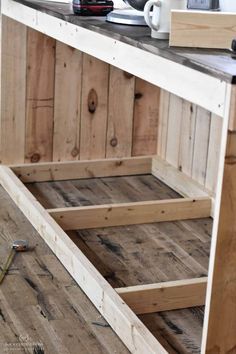 a kitchen island made out of pallets and wooden planks, with the bottom section missing