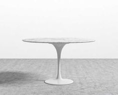 a white table sitting on top of a cement floor