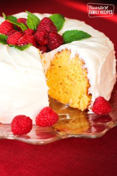 a cake with white frosting and raspberries on top