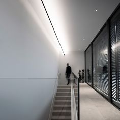 people walking up and down the stairs in an office building with shutters on both sides