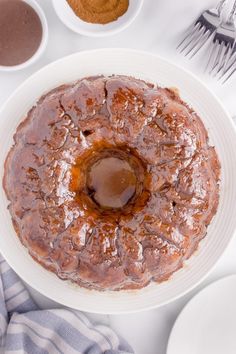 a cake sitting on top of a white plate next to other plates and utensils