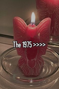 two red candles sitting on top of a glass plate with the words the 1970s written in front of them