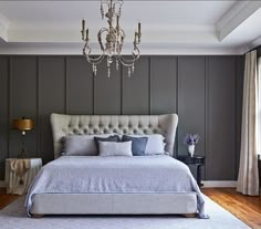 a bedroom with a bed, chandelier and two lamps on the side tables