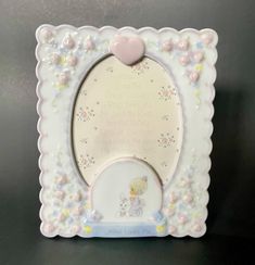 a small white frame with a pink heart on the top and an image of a teddy bear