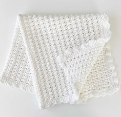 two white crocheted napkins sitting on top of each other