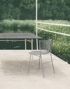 a table and chair sitting on top of a cement floor next to a forest filled with trees