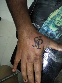 a man's hand with a tattoo on it and the letter p in black ink