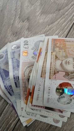 a pile of money sitting on top of a wooden table