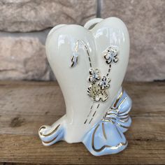 a ceramic toothbrush holder on a wooden table with a brick wall in the background