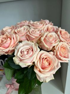 a vase filled with pink roses on top of a table