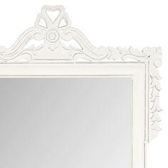 a white framed mirror with an ornate design on the top and bottom edge, against a white background