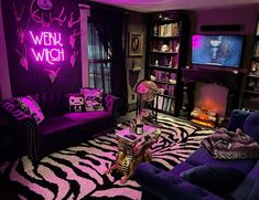 a living room filled with purple furniture and a zebra print rug