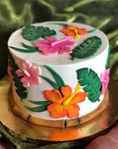 a white cake decorated with flowers and leaves