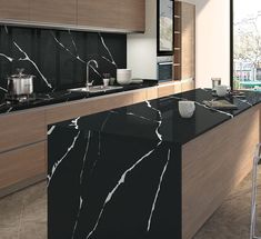 a modern kitchen with black marble countertops and wooden cabinets, along with a bar stool