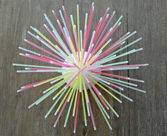 colorful straws arranged in the shape of a star on top of a wooden table