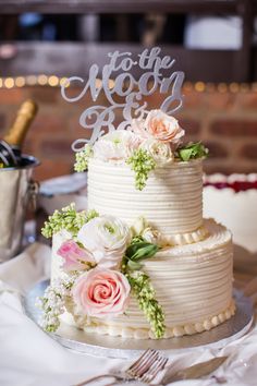 a white wedding cake with flowers on top