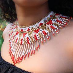 a woman wearing a red and white beaded necklace