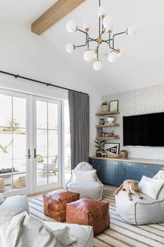 a living room filled with furniture and a flat screen tv mounted to the side of a wall