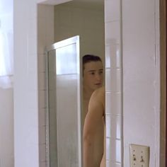 a shirtless man standing in front of a mirror