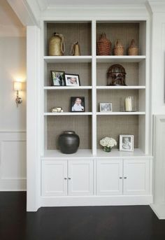 a large white bookcase with pictures on it