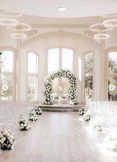 an indoor wedding ceremony with white flowers and greenery