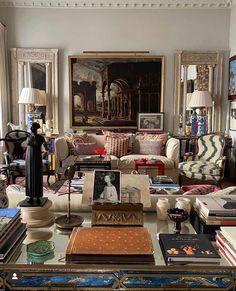 a living room filled with lots of furniture and books on top of a coffee table