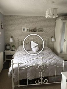 a white bed sitting in a bedroom next to a brick wall